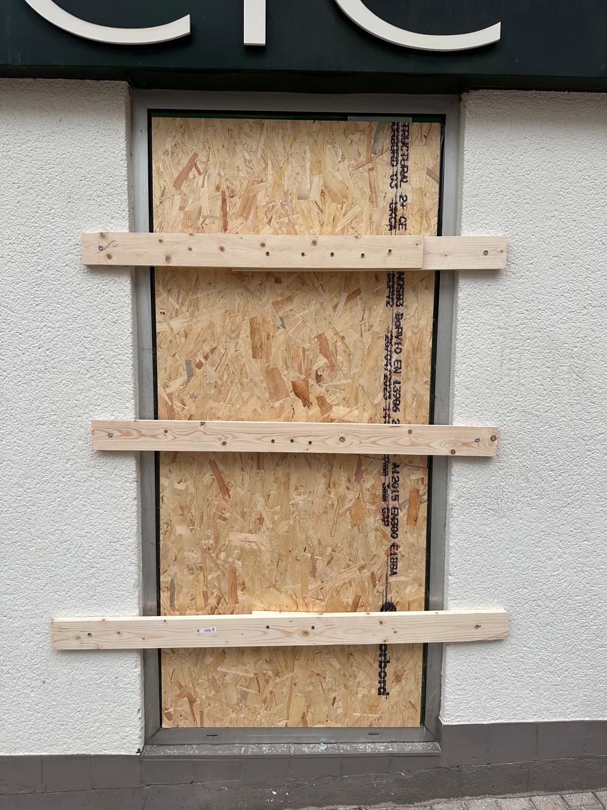 Fenêtre de magasin fermée par un pannage de sécurité en bois