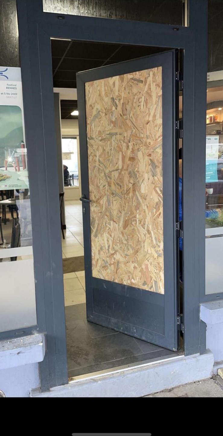 Porte d'entrée sécurisée par un panneau provisoire après incident